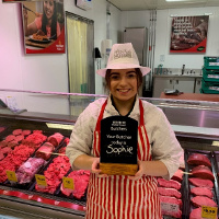 Sophie Fowler standing with 'Your butcher today is…Sophie' sign.
